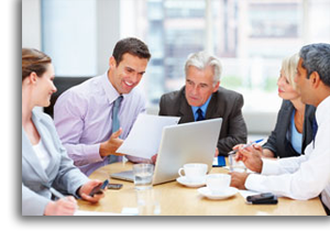 Business men and woman at a conference table sharing information and ideas.